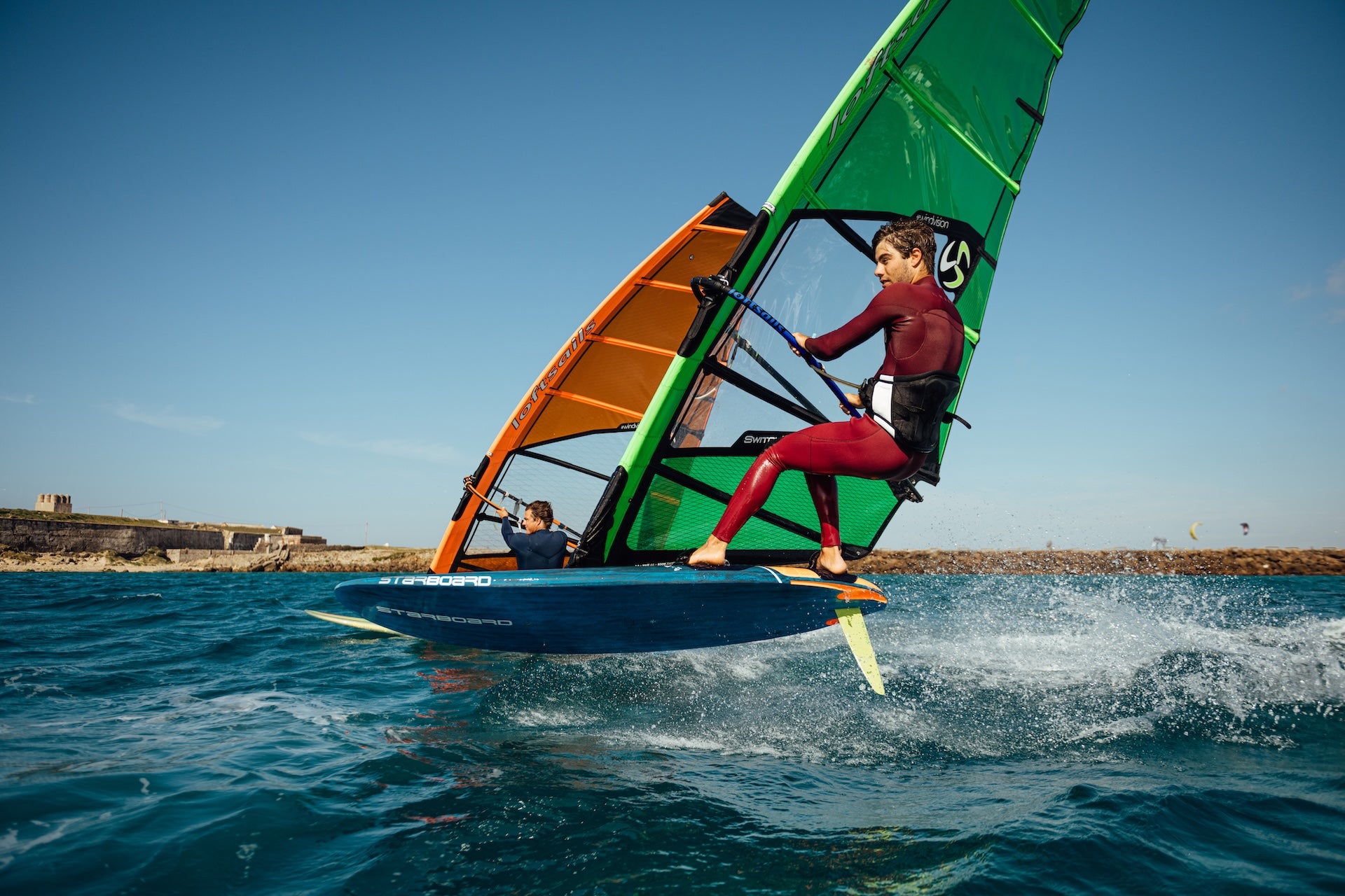 Person windsurfing on a blue ocean with a clear sky
